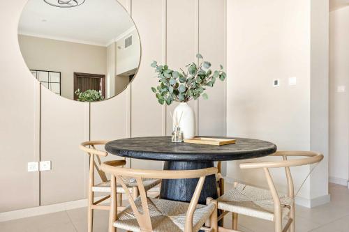a dining room with a round table and a mirror at Silkhaus Vacation Homes Ajwan Tower 1BR with Maid room in Saadiyat Island in Abu Dhabi
