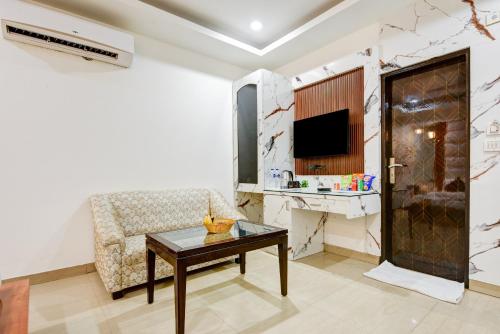 a living room with a couch and a table at Hotel Krishna Deluxe-By RCG Hotels in New Delhi
