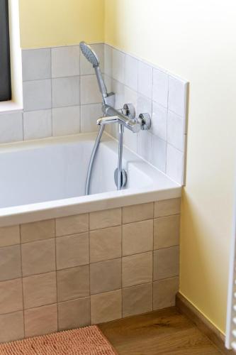 a bath tub with a shower in a bathroom at Villa Couleur in Diksmuide
