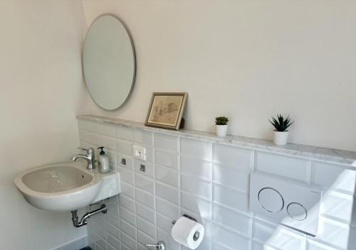 a white bathroom with a sink and a mirror at Podere di Montecchio - Le Andane in Tavarnuzze