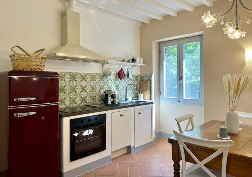 a kitchen with a red refrigerator and a table at Podere di Montecchio - Le Andane in Tavarnuzze