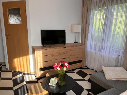a living room with a vase of flowers on a table at Antoniówka in Zakopane