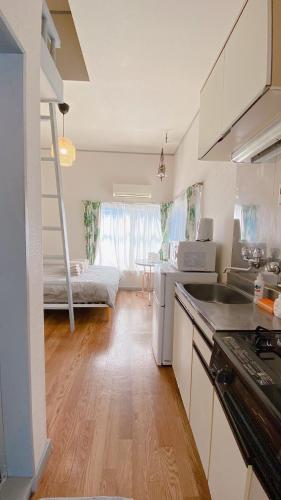 a kitchen with a sink and a bed in a room at Rize Apartments in Tokyo
