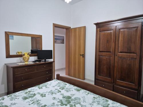 a bedroom with a bed and a dresser and a mirror at Nonno Gigi in Leuca
