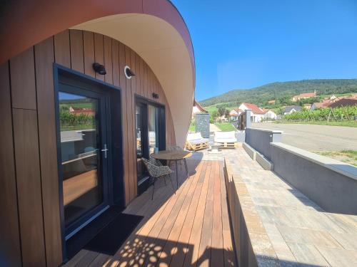a balcony of a house with a door and a table at Au Jardin d'Edel Gîtes Centre Alsace in Dieffenthal