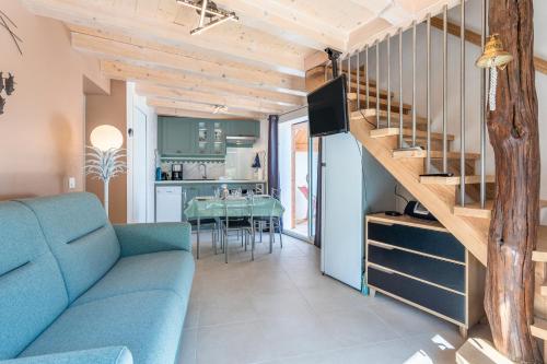 - un salon avec un canapé bleu et un escalier dans l'établissement Le Petit Appartement de Saint-Denis, à Saint-Denis-dʼOléron