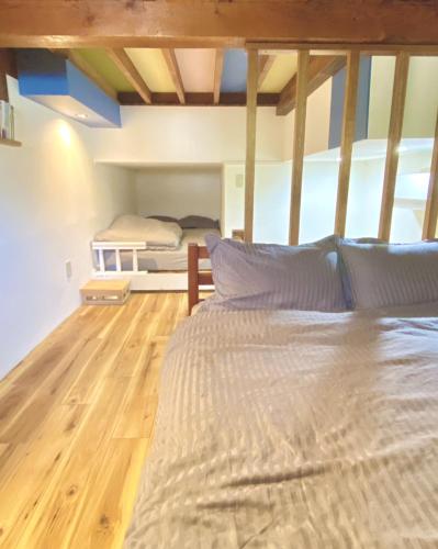 a large bed in a room with a wooden floor at Rize Apartments in Tokyo