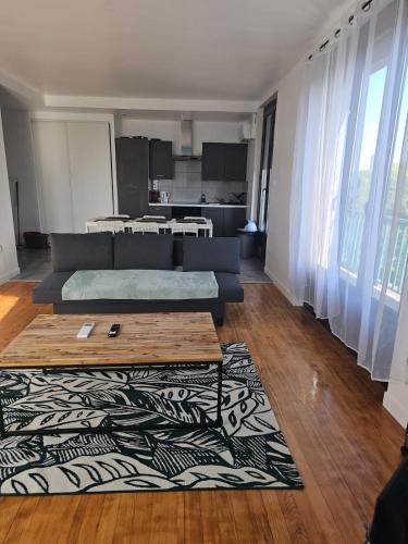 un salon avec un canapé et un tapis dans l'établissement Le beau T3 Fonneuve clim parking facile, à Montauban