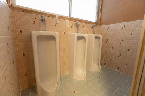 three white urinals in a bathroom with a window at Ichimaru Ryokan - Vacation STAY 59281v in Tenkawa