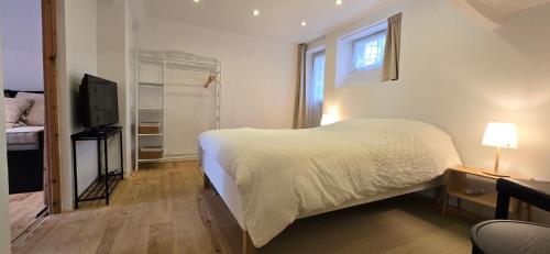 une chambre avec un lit blanc et une télévision dans l'établissement Chambre indépendante grand confort avec parking privé clos en centre ville, à Plérin