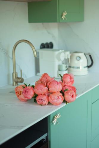 a bunch of pink flowers on a counter in a kitchen at Patri's glamp in Mariánské Lázně