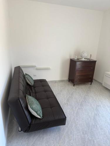 a brown leather couch in a living room with a dresser at ConiBianchi in Ostuni