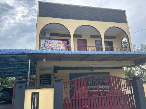 a house with a balcony with a sign on it at Chengai Homestay in Sungkai