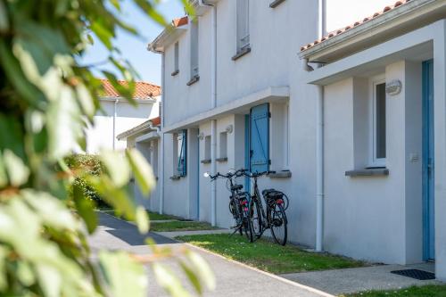 - deux vélos garés à côté d'un bâtiment dans l'établissement Résidence Odalys Le Domaine de l'Océan, à Saint-Brévin-lʼOcéan