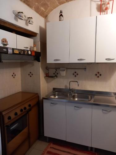 a kitchen with white cabinets and a sink at Al civico 78 in Vasto