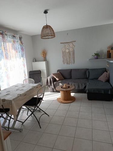 un salon avec un canapé et une table dans l'établissement Entre Terre et Mer, à Villeneuve-lès-Béziers