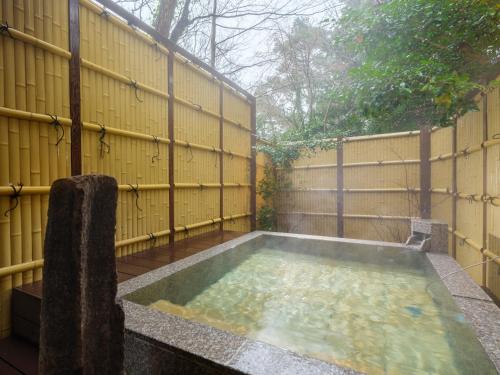 a small pool of water in front of a fence at Mizunoto Reopening on April 1, 2025 in Hakone