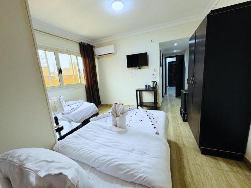 a hotel room with two beds and a mirror at Phoenix Pyramids View Inn in Cairo