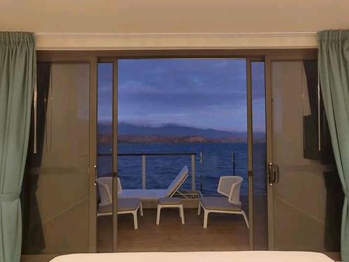 a bedroom with a balcony with a view of the ocean at Loloata Island Resort in Loloata Island