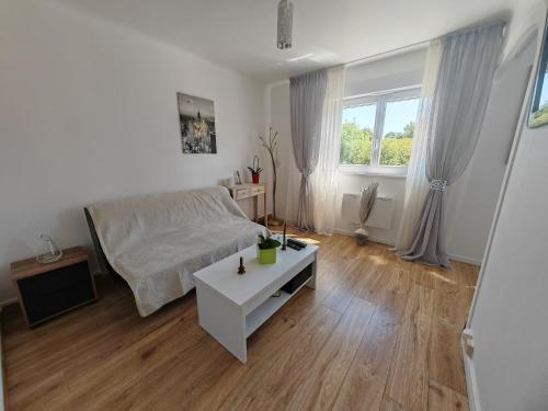 un salon avec un canapé blanc et une table dans l'établissement le Mabileau Saumur, à Saumur