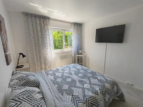 une chambre avec un lit et une télévision à écran plat dans l'établissement le Mabileau Saumur, à Saumur