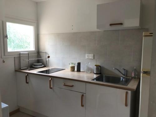 un comptoir de cuisine avec un évier et une fenêtre dans l'établissement studio, clim, balcon et parking, à 2 pas du centre !, à Avignon