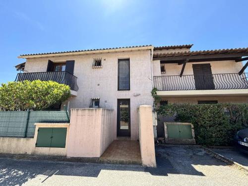 un immeuble d'appartements avec des portes vertes et une allée dans l'établissement Appartement Studio 1 couchages La Londe Les Maures LAL240-033, à La Londe-les-Maures