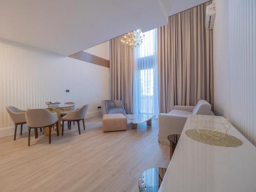 a living room with a couch and a table and chairs at CASA AL MARE RESIDENCE in Bečići