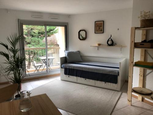 une chambre avec un lit dans le coin d'une pièce dans l'établissement studio, clim, balcon et parking, à 2 pas du centre !, à Avignon