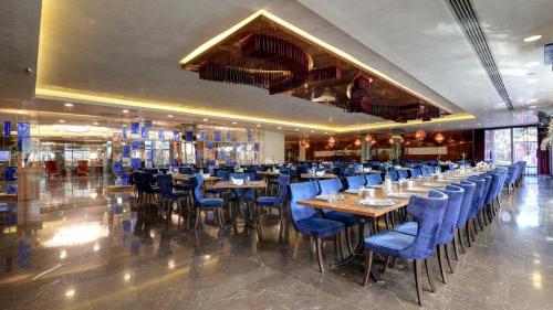a restaurant with blue chairs and tables in a room at Gold Majesty Hotel in Bursa