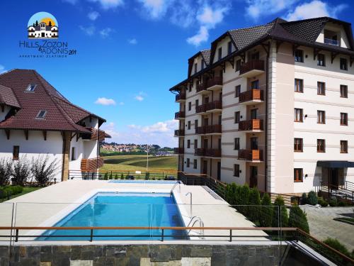 a hotel with a swimming pool in front of a building at Adonis 201 in Zlatibor