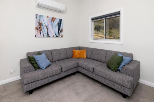 a gray couch with an orange and blue pillow at BIG4 Launceston Holiday Park in Launceston