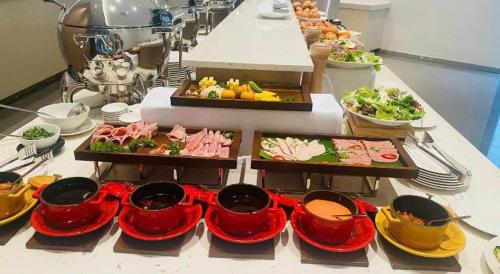 a buffet with many plates of food on a table at Arena jakovi condotel in Cam Ranh