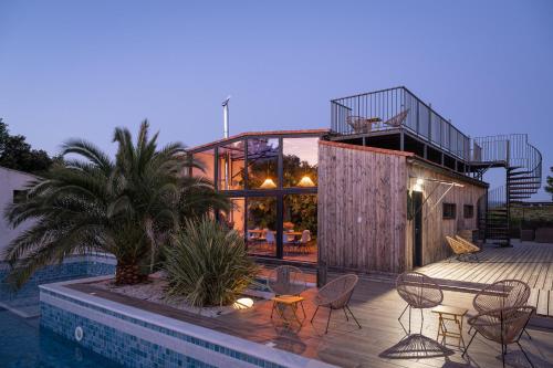 une maison avec une piscine, une table et des chaises dans l'établissement NUIKI Lodges - Gites, à Montségur-sur-Lauzon
