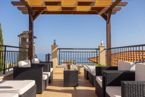 a patio with chairs and tables on a balcony at Paradise Cove in Neo Chorio