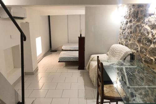 Cette chambre comprend 2 lits et une table en verre. dans l'établissement Le Limouzy - appartement proche des halles, à Narbonne