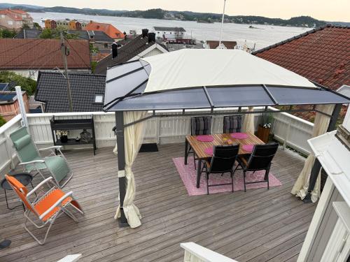 a patio with a table and chairs under an umbrella at Monas sommerresidens midt i hjertet av Kragerø in Kragerø
