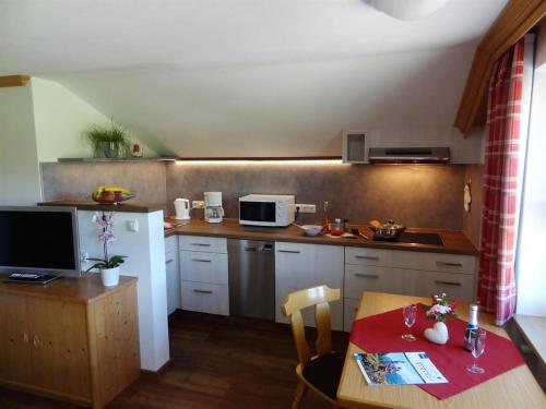 a kitchen with a table and a small kitchen with a table and a kitchen at Gästehaus Koros in Fischen