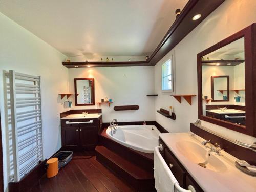 une salle de bain avec une baignoire et un lavabo et une baignoire dans l'établissement Maison avec piscine chemin d'erbajolo proche centre Ajaccio, à Ajaccio