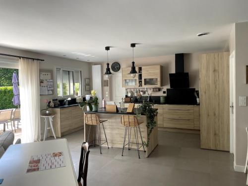 une cuisine avec une table, des chaises et un comptoir dans l'établissement Villa aux portes du médoc, à Saint-Aubin-de-Médoc