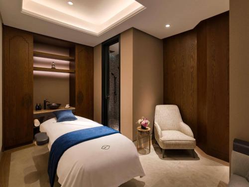 a bedroom with a bed and a chair at Fairmont Tazi Palace Tangier in Tangier