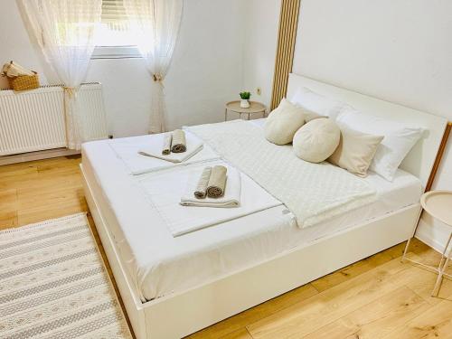 a bedroom with a white bed with two plates on it at Zayed Residence in Mostar