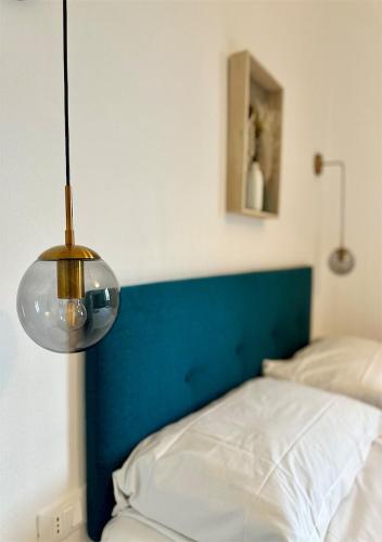 a bed with a blue head board and a lamp at Podere di Montecchio - Le Andane in Tavarnuzze