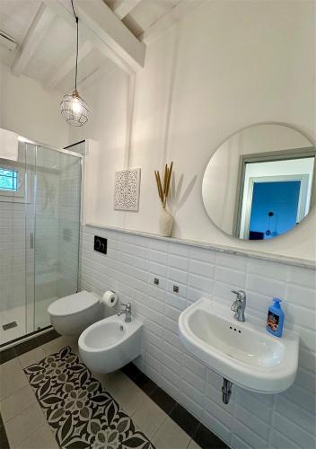 a white bathroom with a sink and a mirror at Podere di Montecchio - Le Andane in Tavarnuzze