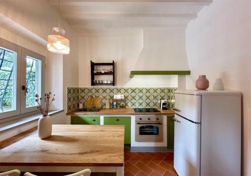 a kitchen with a white refrigerator and a table at Podere di Montecchio - Le Andane in Tavarnuzze