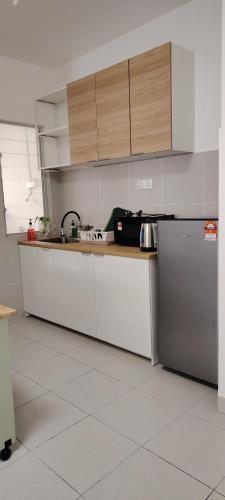 a kitchen with white counters and stainless steel appliances at J&K Guesthouse at Harmoni Apartment, Eco Majestic in Beranang