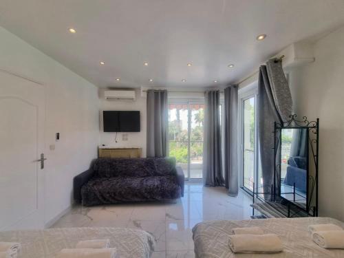 un salon avec un lit et une télévision dans l'établissement Appartement Le Bosquet Martinez à Cannes, à Cannes