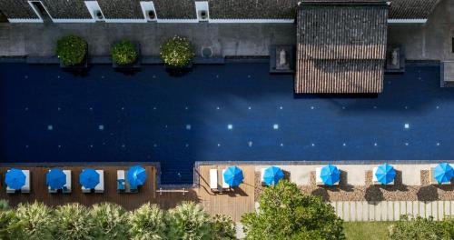 an overhead view of a swimming pool with blue umbrellas at Awa Resort Koh Chang in Ko Chang