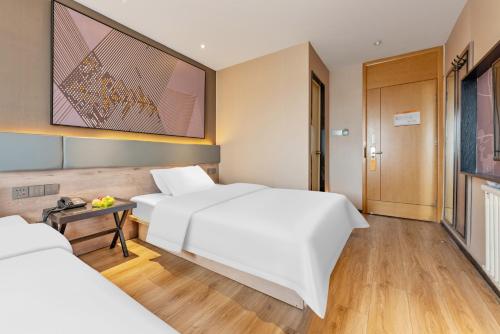 Ένα ή περισσότερα κρεβάτια σε δωμάτιο στο iU Hotel Binzhou Bohai International RT-Mart Store