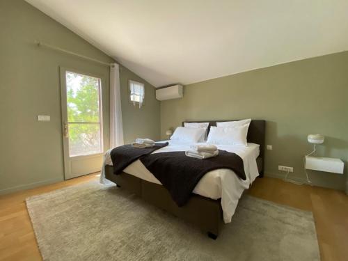 een slaapkamer met een groot bed en een raam bij Villa Férus Piscine chauffée in Buis-les-Baronnies